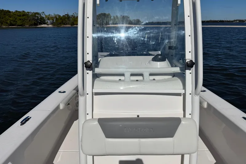 Slide: The Image of 2017 Everglades 243 Center Console boat on calm water, showcasing helm and seating. - 13