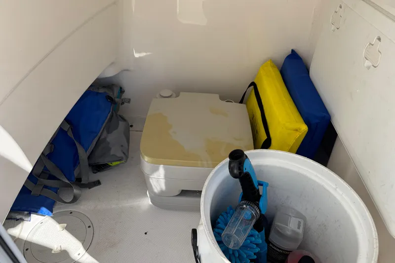Slide: The Image of Storage area of a 2017 Everglades 243 Center Console boat with cleaning supplies and life jackets. - 22