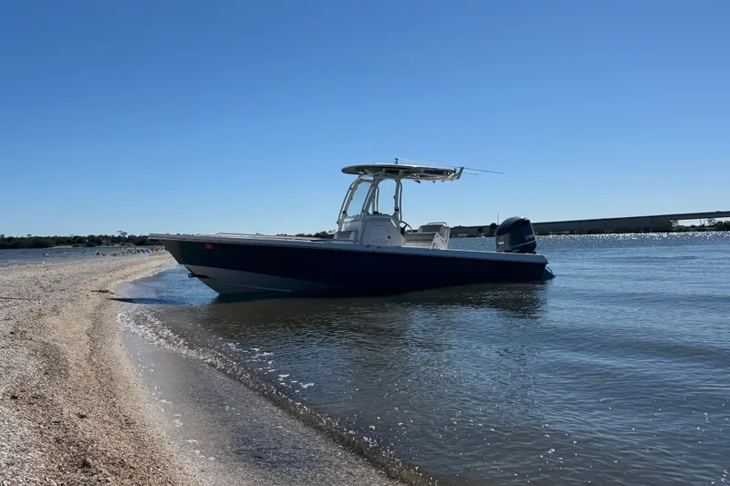 Slide: The Image of 2017 Everglades 243 Center Console boat on a sandy beach under clear blue sky. - 3
