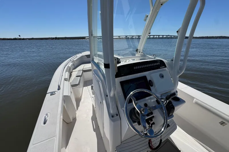 Slide: The Image of 2017 Everglades 243 Center Console boat on calm water, featuring sleek design and modern controls. - 4