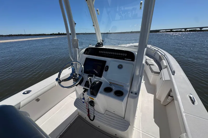 Slide: The Image of 2017 Everglades 243 Center Console boat on calm water, featuring a sleek helm design. - 6
