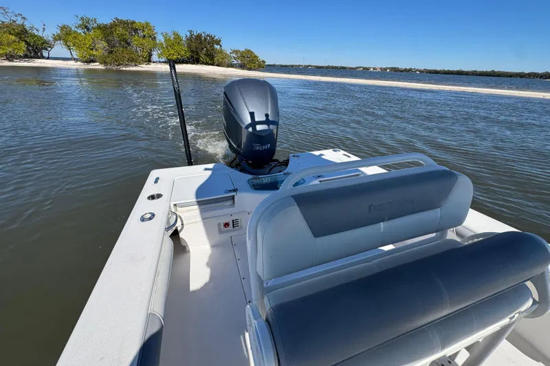 Slide: The Image of 2017 Everglades 243 Center Console boat cruising near a sandy shoreline. - 7