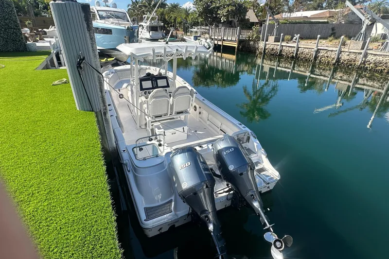 Slide: The Image of 2023 Sea Fox 268 Commander boat docked with twin 150 engines, calm water reflection. - 21
