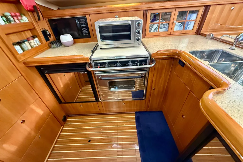 Slide: The Image of DUET galley with wood cabinetry, oven, microwave, and dual sink. - 24