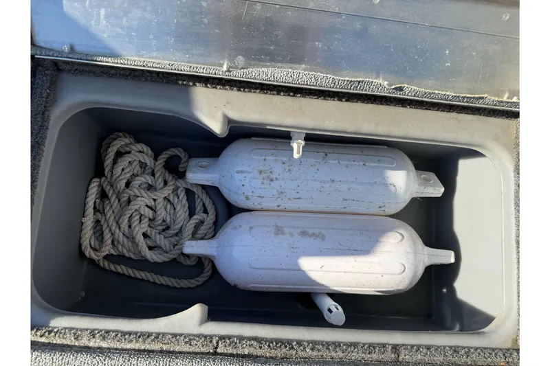 Slide: The Image of Storage compartment in 2017 Tracker Pro Team 175 TF with rope and boat fenders. - 12