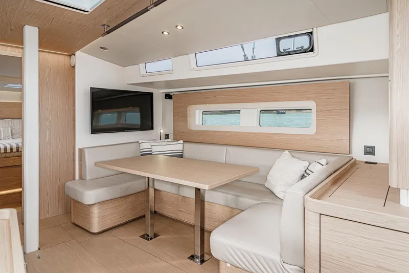Slide: The Image of Luxurious interior of 2022 Beneteau Oceanis Yacht 54 with modern dining area and TV. - 12