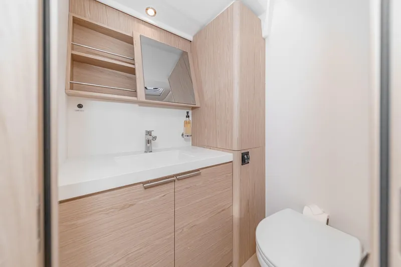 Slide: The Image of Modern bathroom interior on 2022 Beneteau Oceanis Yacht 54, featuring sleek wood cabinetry. - 17