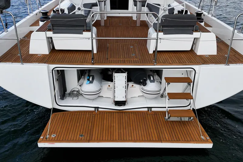 Slide: The Image of 2022 Beneteau Oceanis Yacht 54 stern view with open storage and wooden deck. - 52