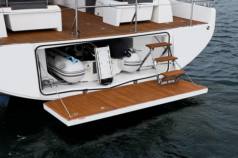 Slide: The Image of 2022 Beneteau Oceanis Yacht 54 with open swim platform and stored dinghy. - 53