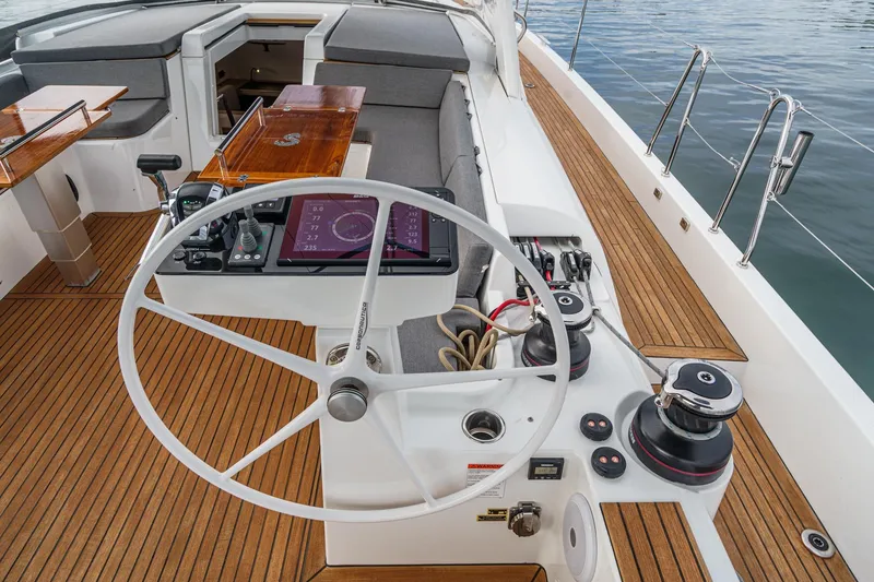 Slide: The Image of Cockpit of 2022 Beneteau Oceanis Yacht 54 with steering wheel and navigation controls. - 55