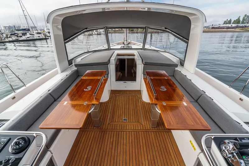 Slide: The Image of Luxurious 2022 Beneteau Oceanis Yacht 54 cockpit with elegant wooden tables and seating. - 66