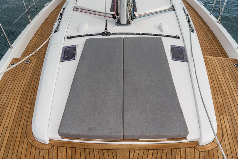 Slide: The Image of 2022 Beneteau Oceanis Yacht 54 deck with sunbathing cushions and teak flooring. - 76