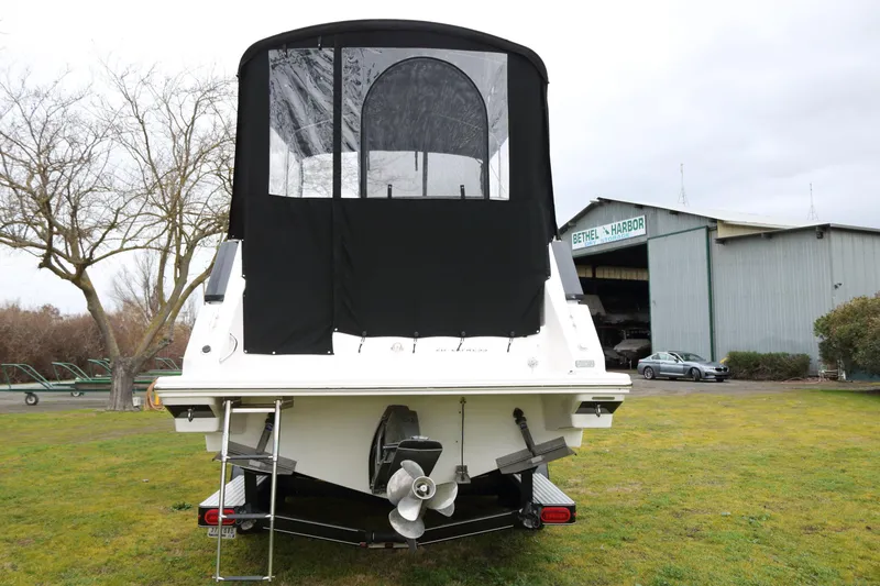 Slide: The Image of Rear view of a 2018 Regal 26 Express boat with black canopy. - 2