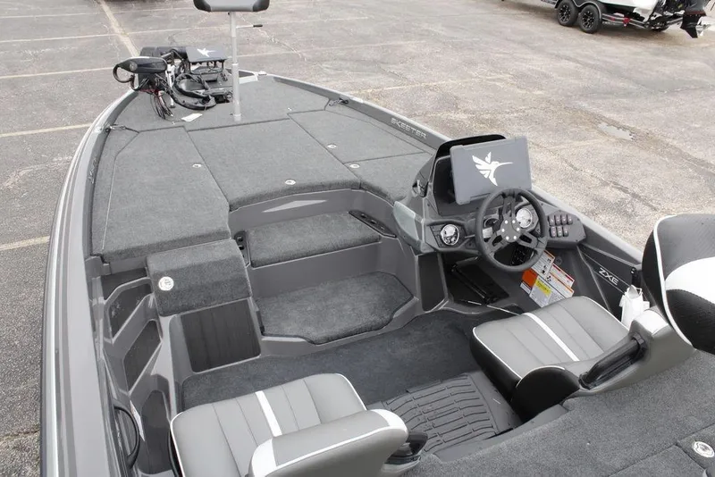 Slide: The Image of 2026 Skeeter ZXE21 boat interior with steering console and seating, parked on pavement. - 22