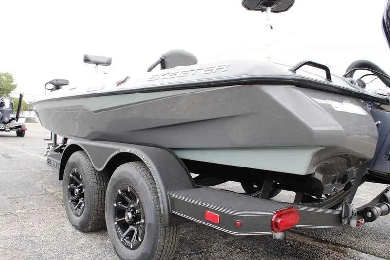 Slide: The Image of 2026 Skeeter ZXE21 boat on trailer, showcasing sleek design and dual wheels. - 27