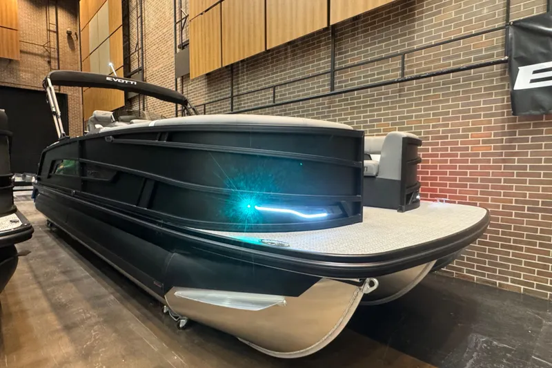 Slide: The Image of 2026 Evotti 725QL pontoon boat displayed indoors with sleek black design. - 0
