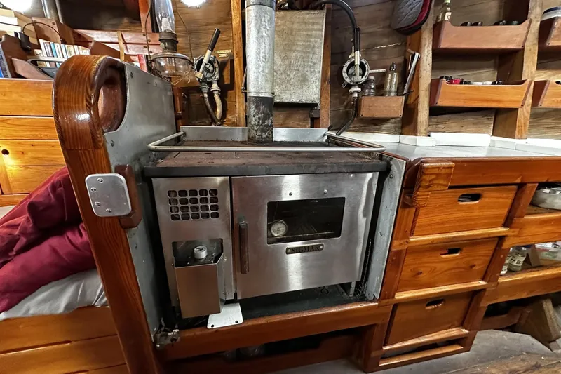 Slide: The Image of Vintage wood stove in a 2005 custom sail-assisted trawler's cozy wooden interior. - 11