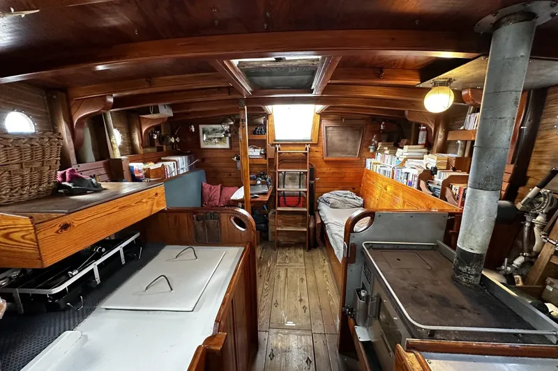 Slide: The Image of Interior of a 2005 custom sail-assisted trawler with wooden furnishings and cozy living space. - 13