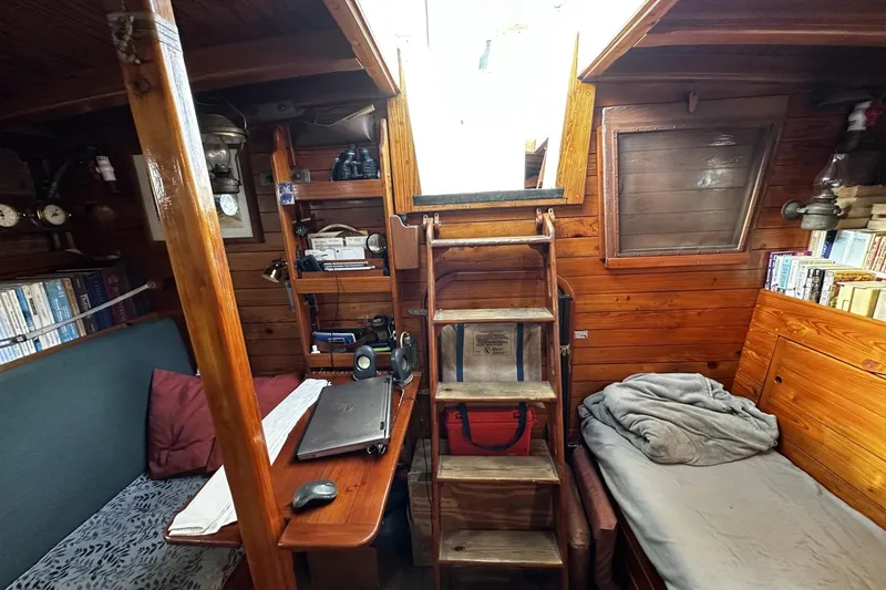 Slide: The Image of Cozy cabin interior of a 2005 custom sail-assisted trawler with wooden decor and bookshelves. - 15