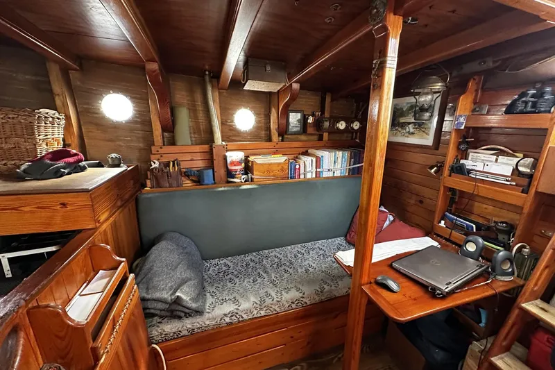 Slide: The Image of Cozy cabin interior of 2005 Custom Sail-Assisted Trawler with wooden furnishings and bookshelves. - 16