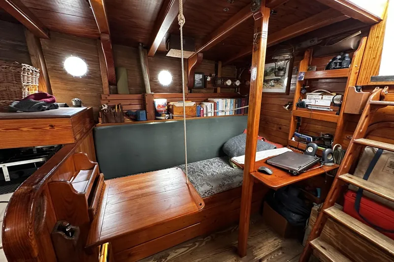 Slide: The Image of Cozy interior of a 2005 custom sail-assisted trawler with wooden furnishings and nautical decor. - 17