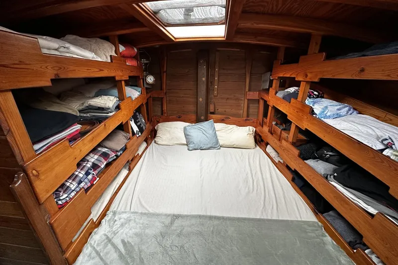 Slide: The Image of Cozy cabin interior of 2005 custom sail-assisted trawler with wooden bunk beds and skylight. - 19