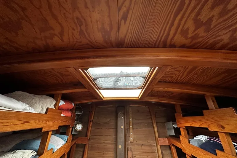 Slide: The Image of Interior of 2005 custom sail-assisted trawler with wooden bunk beds and skylight. - 24