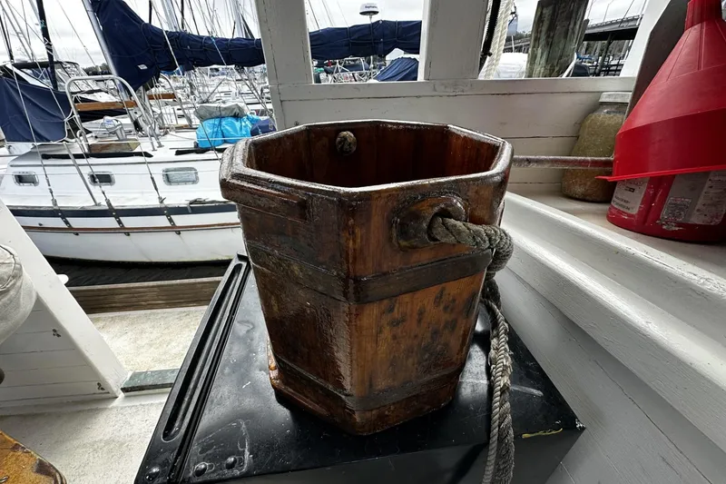 Slide: The Image of Wooden bucket with rope handle on a sail-assisted trawler, docked at a marina. - 33
