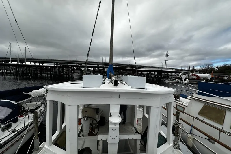 Slide: The Image of Custom 2005 sail-assisted trawler docked under cloudy skies near a bridge. - 37