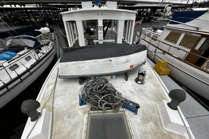 Slide: The Image of 2005 Custom Sail-Assisted Trawler docked, featuring deck ropes and nautical equipment. - 42