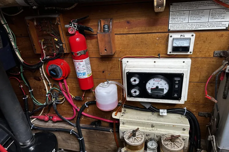 Slide: The Image of Engine room of 2005 custom sail-assisted trawler with gauges, wiring, and fire extinguisher. - 46