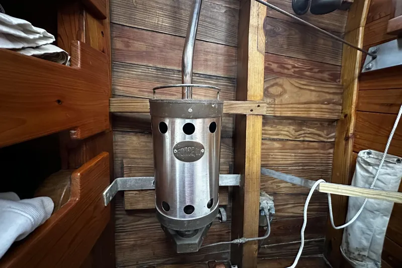 Slide: The Image of Custom 2005 sail-assisted trawler interior with vintage metal heater and wooden paneling. - 52