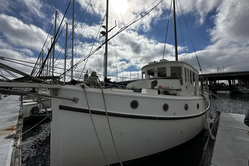 Slide: The Image of Custom 2005 sail-assisted trawler docked at marina under cloudy sky. - 61