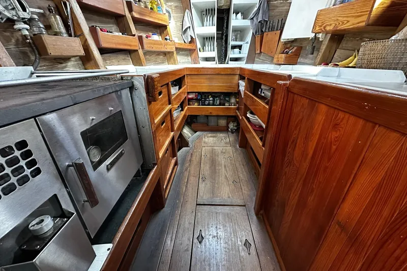 Slide: The Image of Wooden galley interior of 2005 Custom Sail-Assisted Trawler with stove and storage. - 8