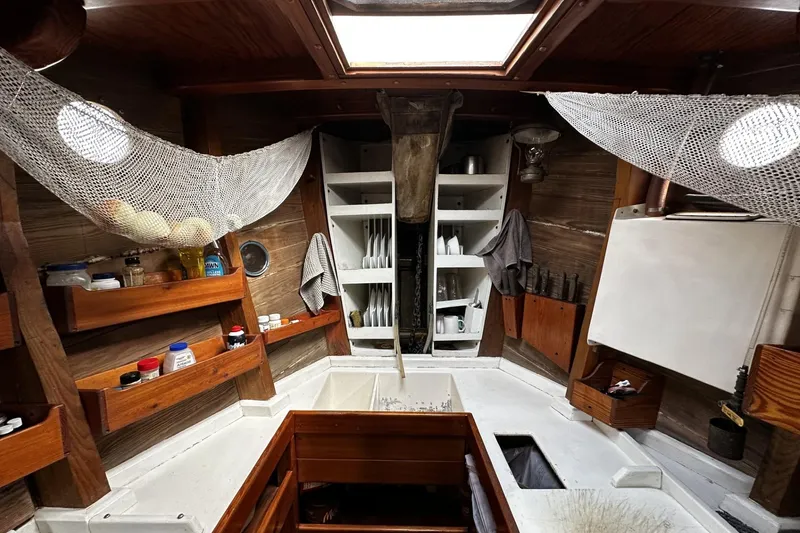 Slide: The Image of Interior of a 2005 custom sail-assisted trawler with wooden shelves and nautical decor. - 9