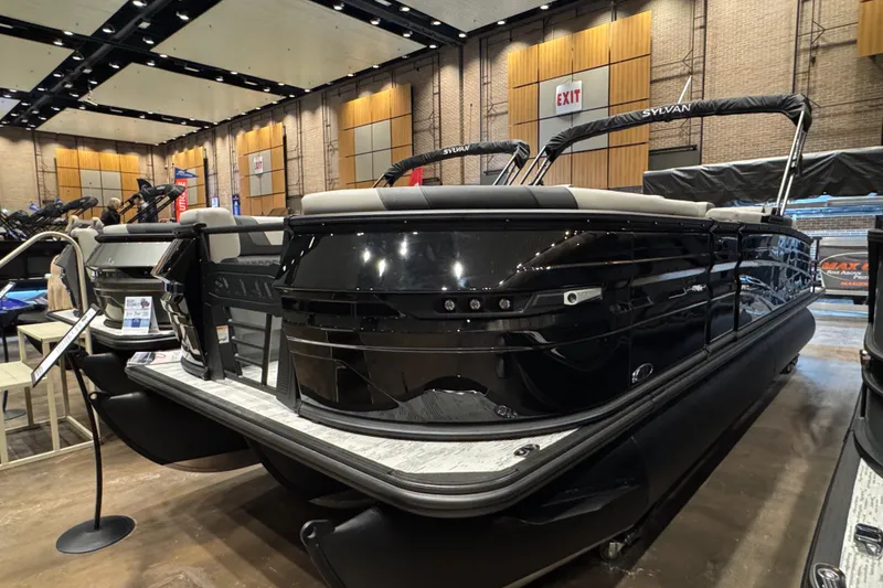 The Image of 2026 Sylvan L3 DLZ Bar pontoon boat displayed indoors at a boat show. - 1