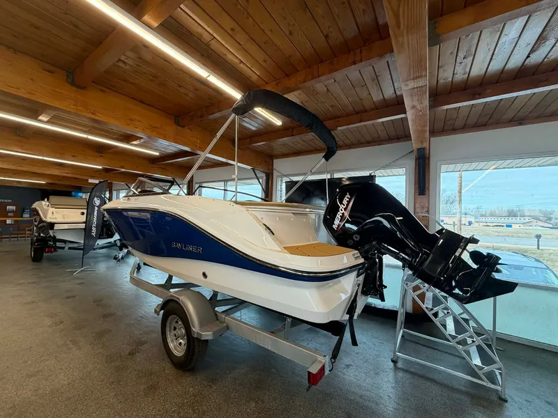 Slide: The Image of 2026 Bayliner V20 boat in showroom with outboard motor. - 2