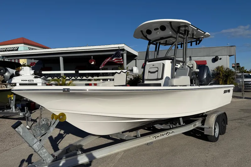 The Image of 2025 Sea Pro 230 Bay boat on trailer, displayed outdoors under clear blue sky. - 1