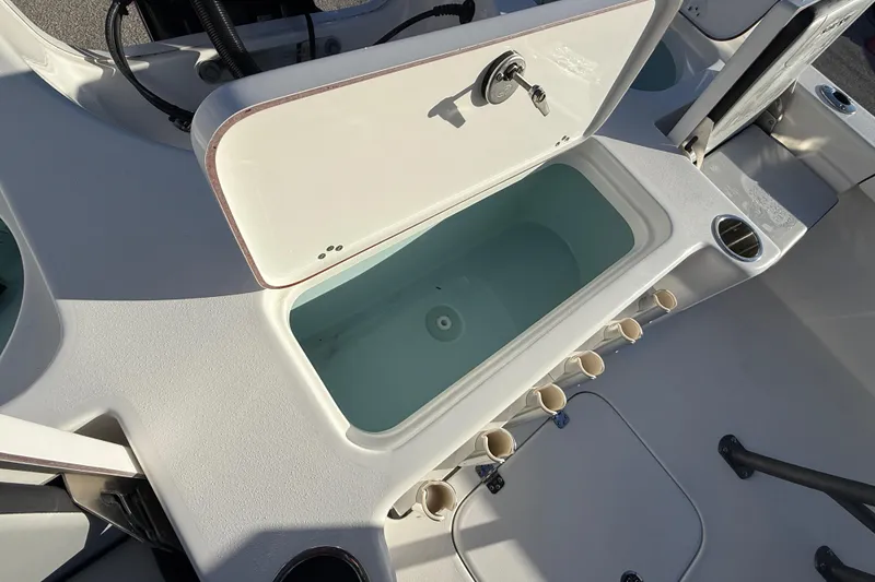 Slide: The Image of 2025 Sea Pro 230 Bay boat interior with open storage compartment and cup holders. - 25