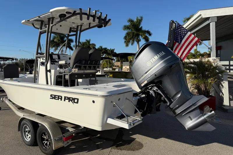 Slide: The Image of 2025 Sea Pro 230 Bay boat with Yamaha engine, parked on a trailer, American flag displayed. - 9
