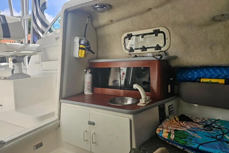 Slide: The Image of 2001 Robalo 2440 Walkaround cabin interior with kitchenette and seating area. - 6