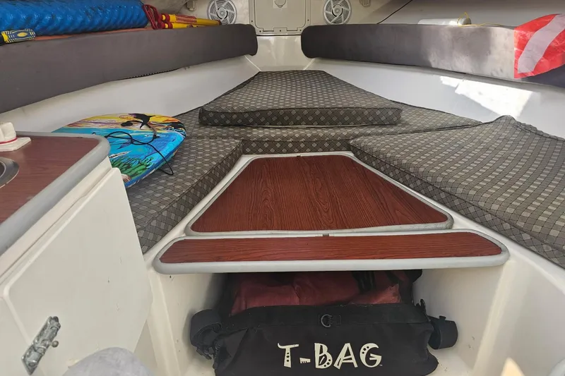 Slide: The Image of Interior of 2001 Robalo 2440 Walkaround boat with cushioned seating and storage. - 7