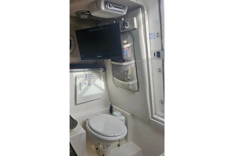 Slide: The Image of 2001 Robalo 2440 Walkaround boat interior with toilet and mounted TV. - 9