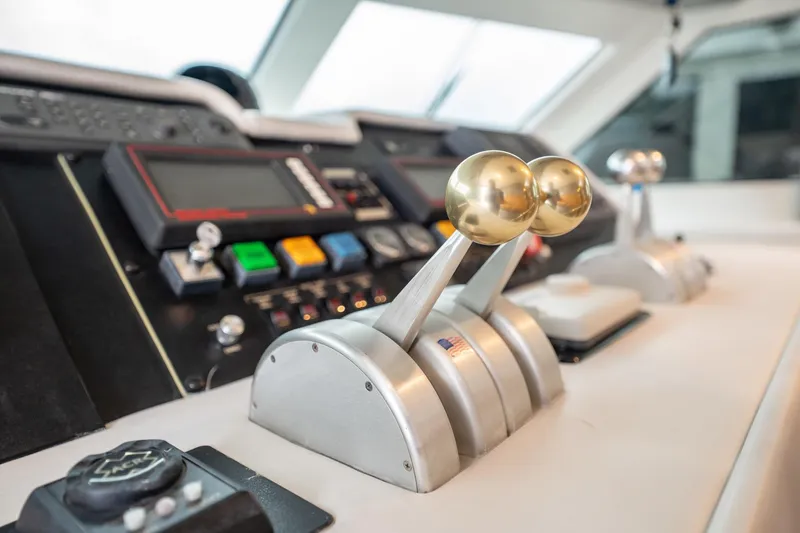 Slide: The Image of Control panel of 1998 Hatteras 74 Cockpit Motor Yacht with throttle levers and navigation instruments. - 18