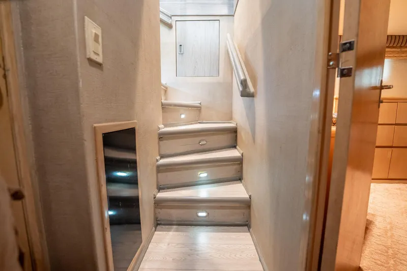 Slide: The Image of Staircase inside 1998 Hatteras 74 Cockpit Motor Yacht with modern lighting and wooden finish. - 21