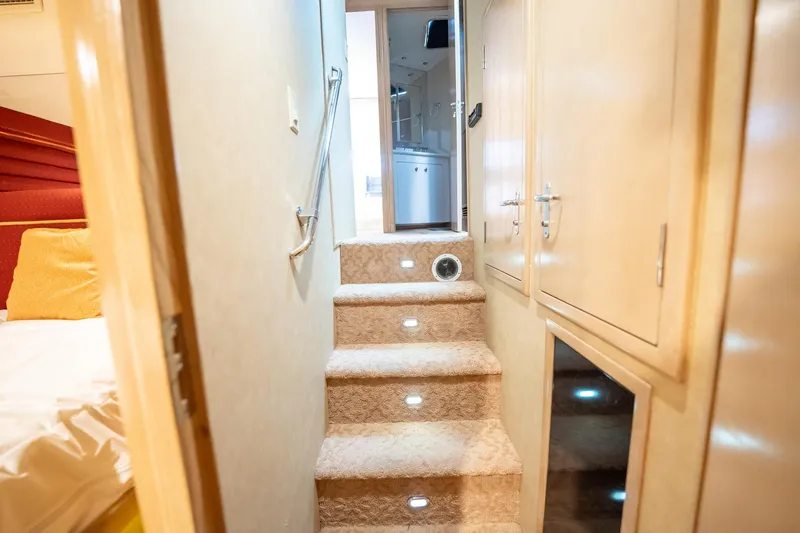 Slide: The Image of Interior of 1998 Hatteras 74 Cockpit Motor Yacht with carpeted stairs and wooden cabinetry. - 29