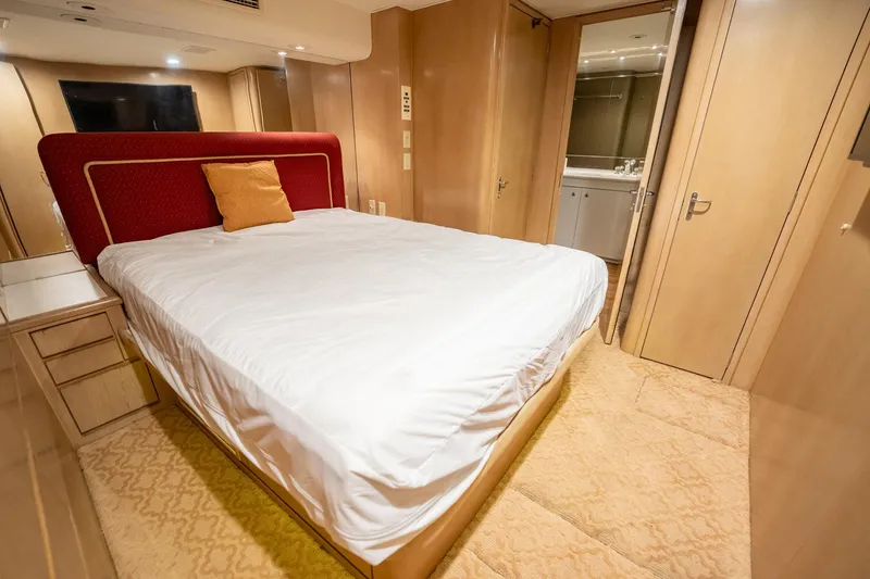 Slide: The Image of Luxurious bedroom interior of 1998 Hatteras 74 Cockpit Motor Yacht with elegant wood paneling. - 30