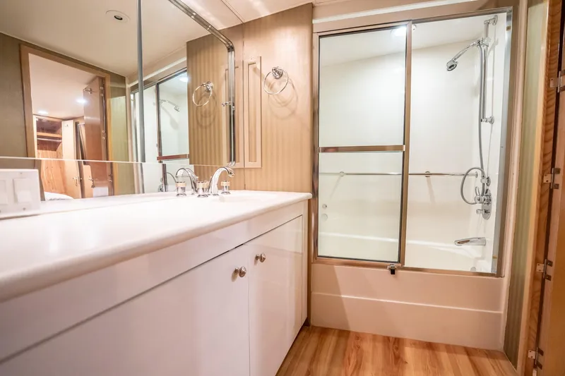 Slide: The Image of Luxurious bathroom in 1998 Hatteras 74 Cockpit Motor Yacht with modern fixtures and wood accents. - 32