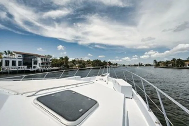 Slide: The Image of 1998 Hatteras 74 Cockpit Motor Yacht cruising on a scenic waterway. - 41