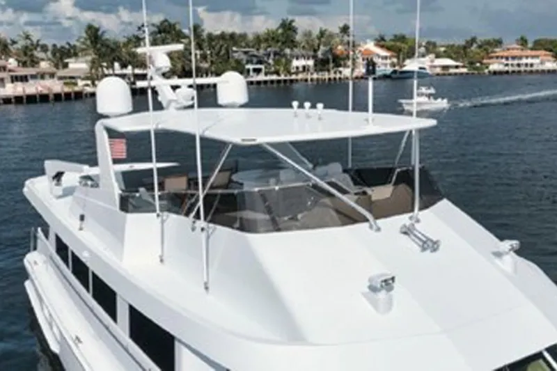 Slide: The Image of 1998 Hatteras 74 Cockpit Motor Yacht cruising on a scenic waterway. - 42